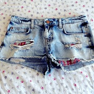 Cutoff denim shorts with printed pocket detail.
